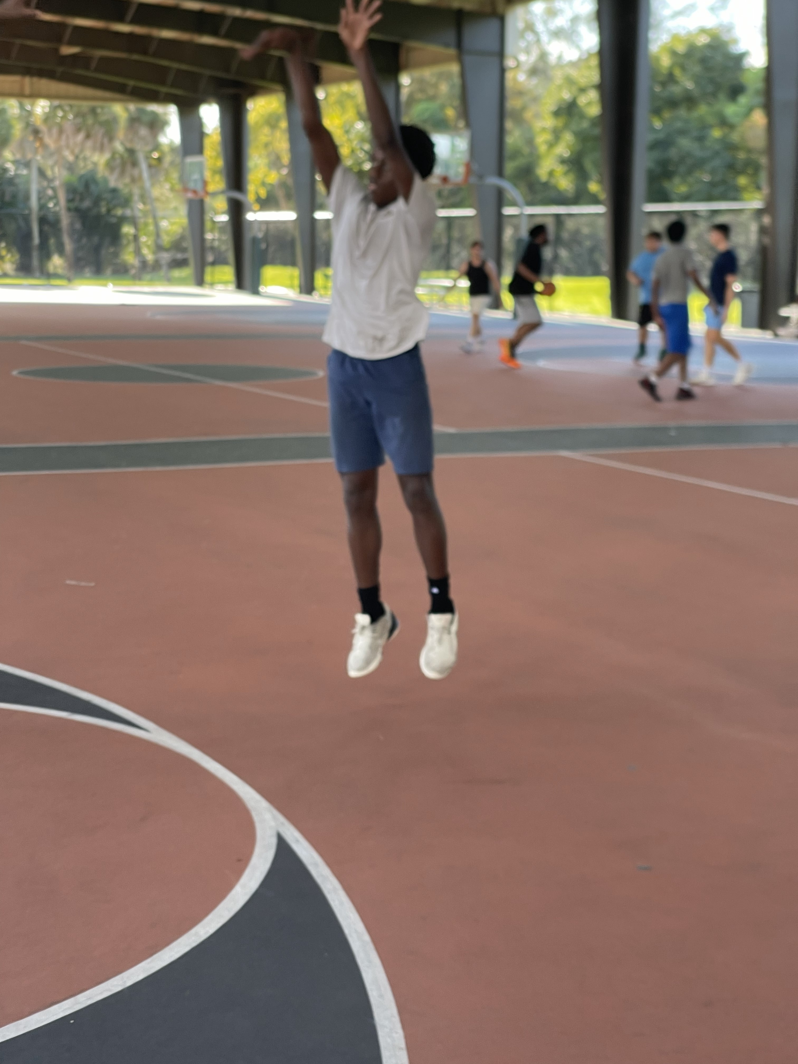 Teen player shooting a contested jumper
